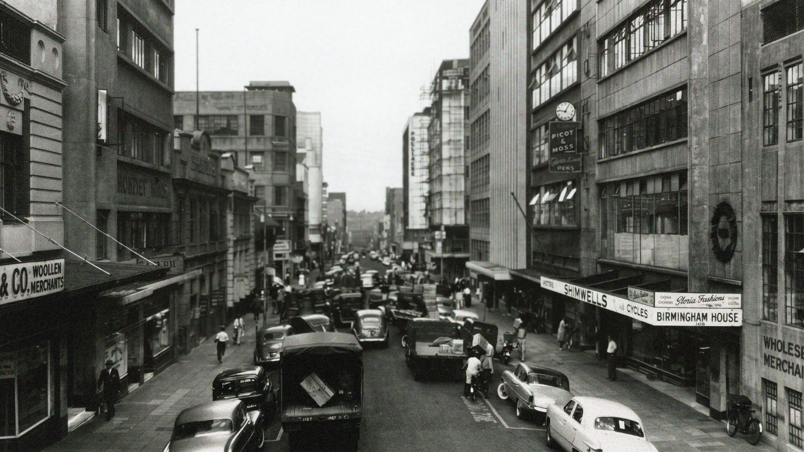 Picot & Moss storefront sign and clock on a busy Johannesburg street, historical photograph
